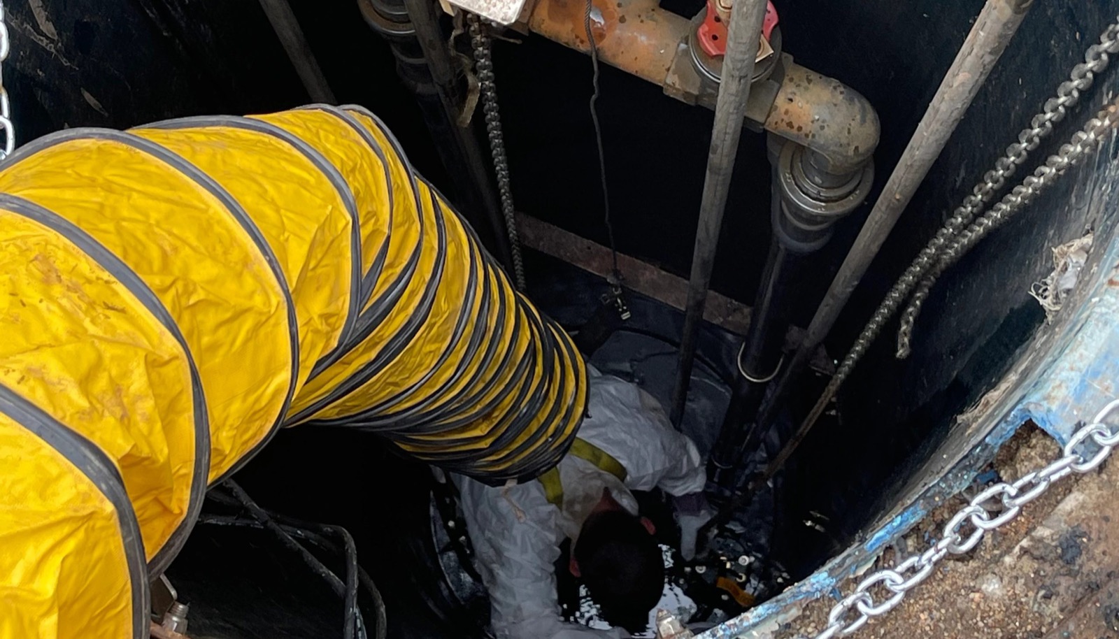 Manhole work with a yellow vent hose on a large utility project near Broken Arrow