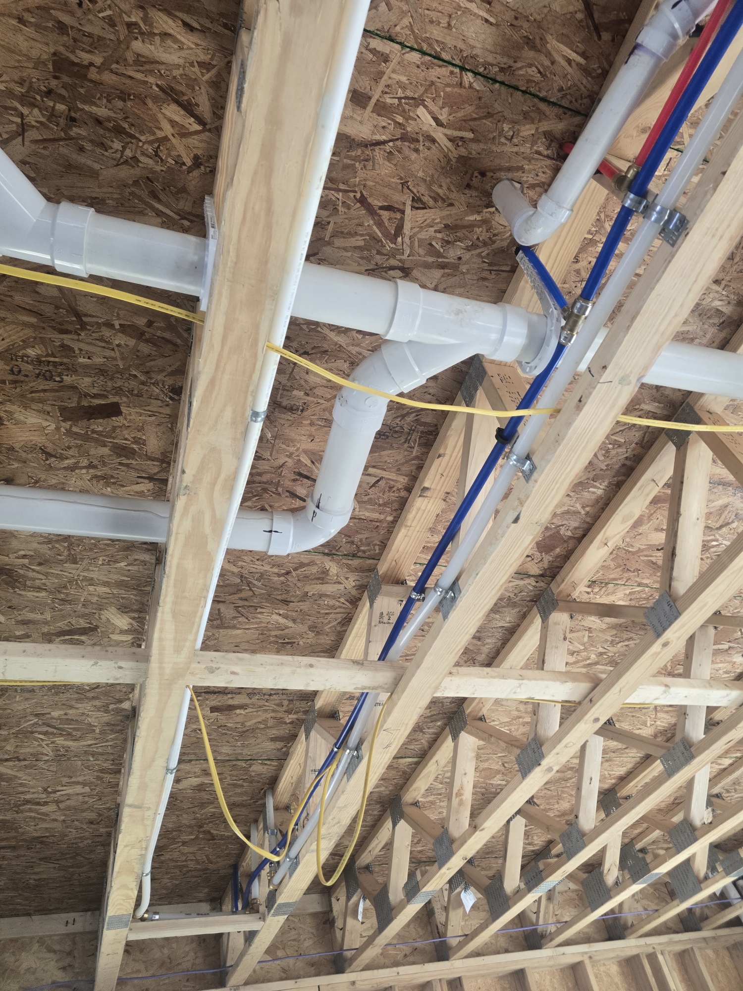Commercial DWV PVC rough-in piping installation during construction framing