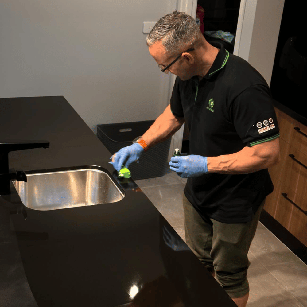Man applying ceramic coating on kitchen bench top