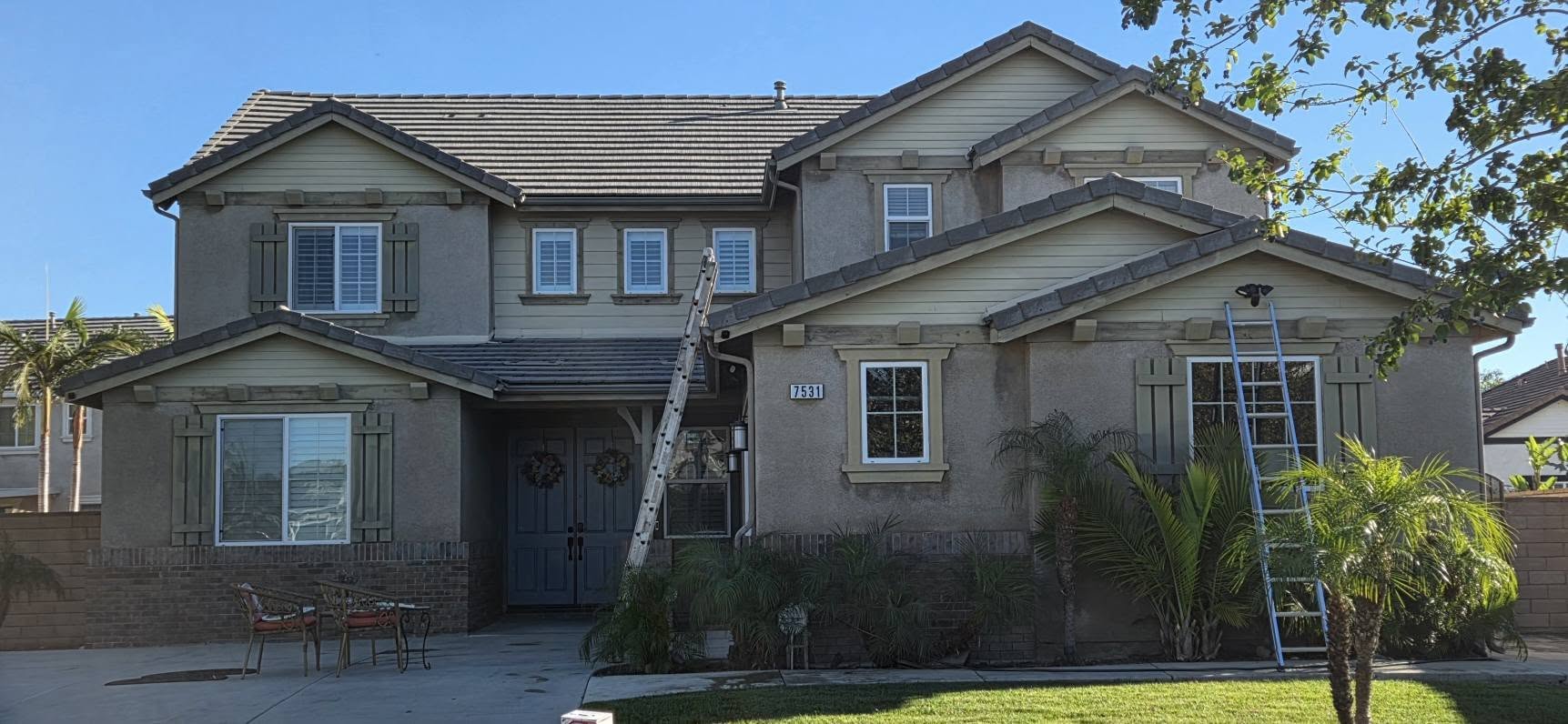 Before: two-story Temecula home with faded olive and grey stucco, worn trim and dated shutters.