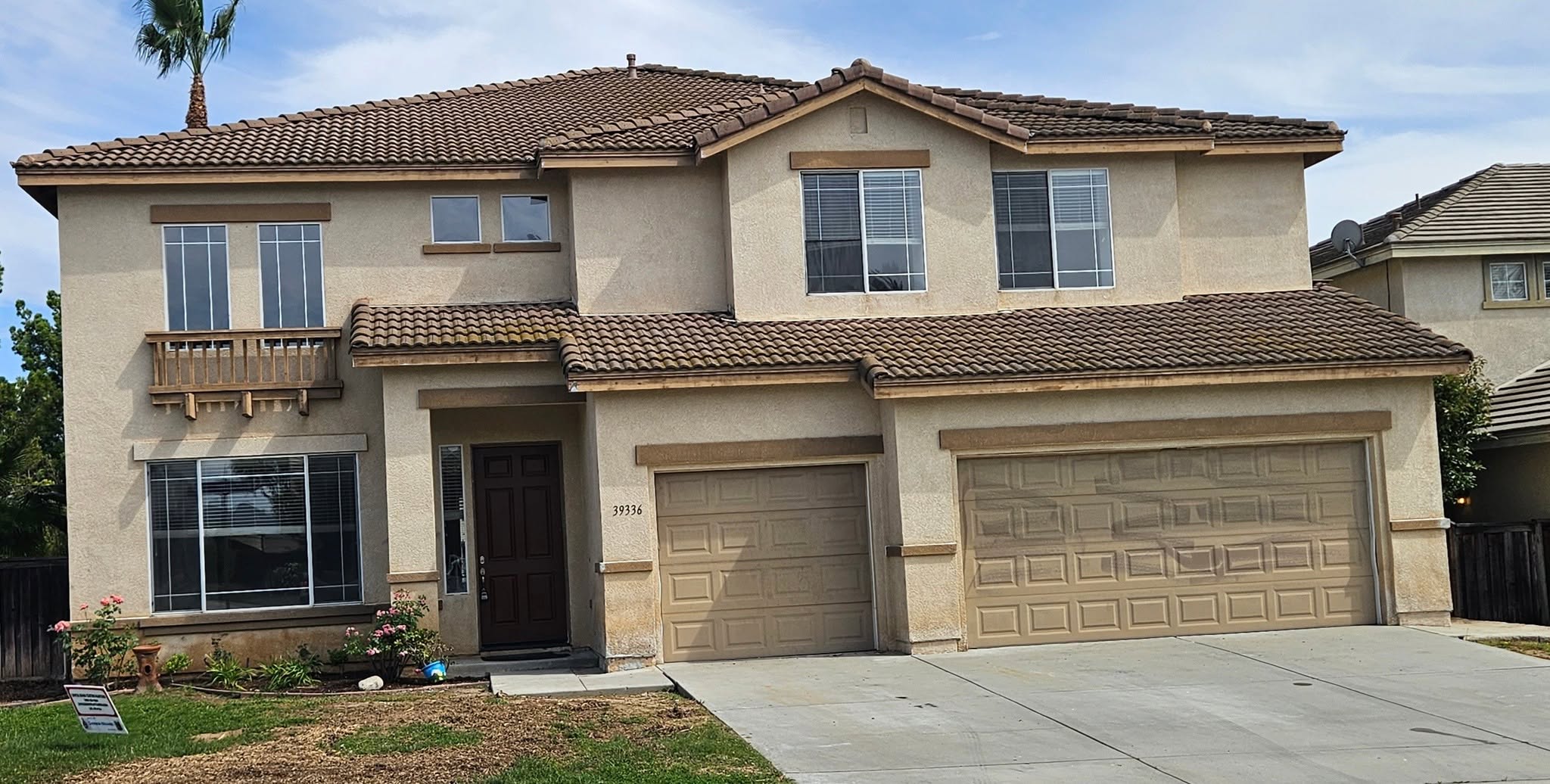 Before: sun-bleached tan stucco home with weathered wood trim and dated tan garage doors.