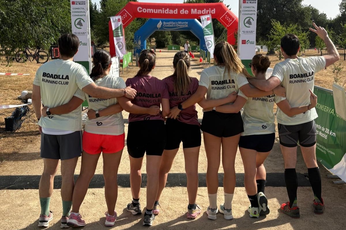 Participantes con camisetas SANO Boadilla ante el arco de una carrera.