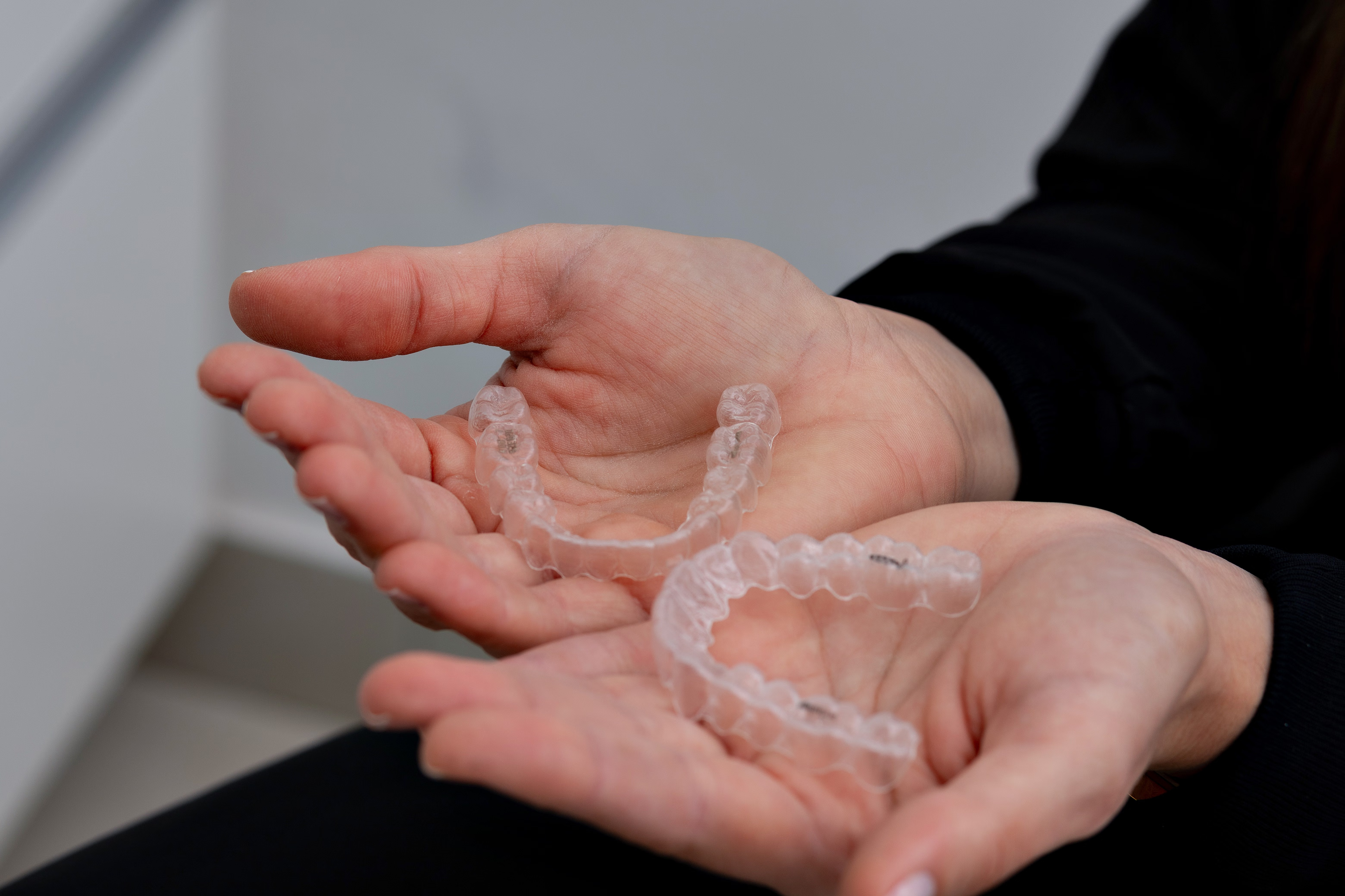 Clear aligners held in both hands