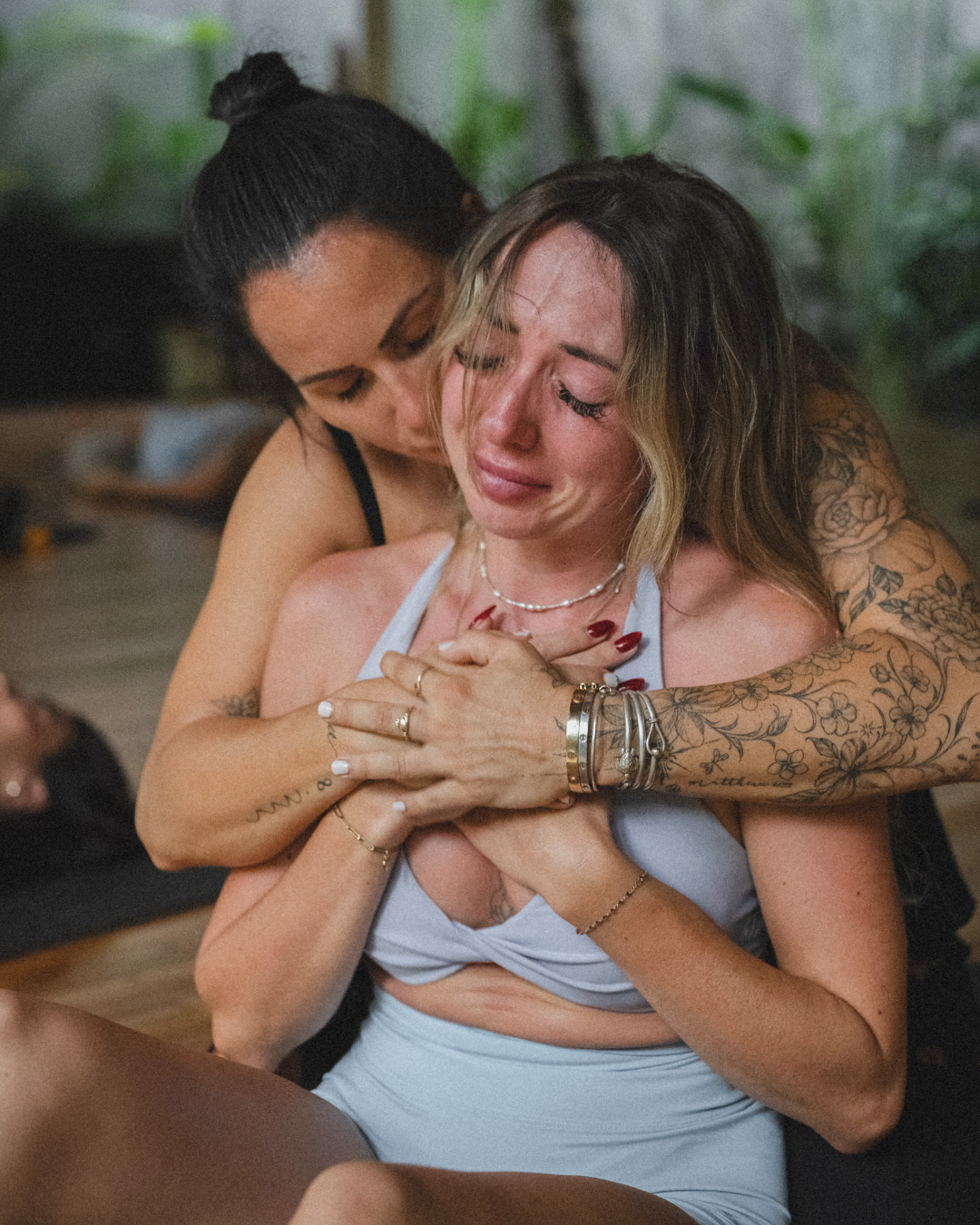 A woman held through an emotional release, experiencing the work in her own body