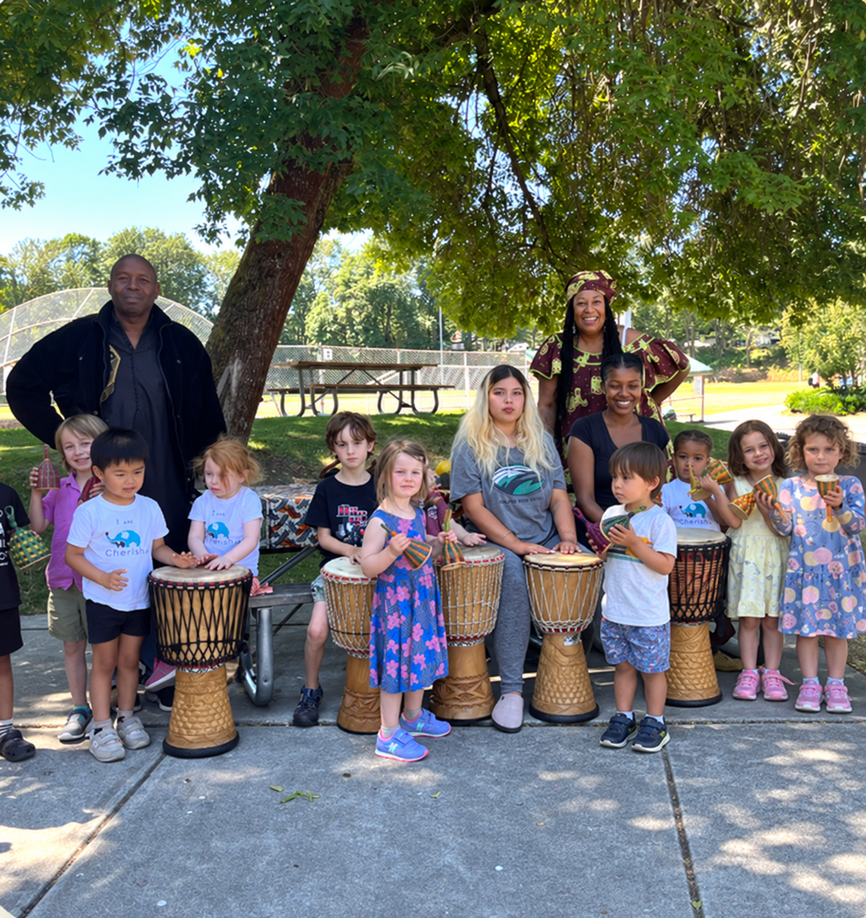 Cherish Academy children and teachers making music with drums outdoors