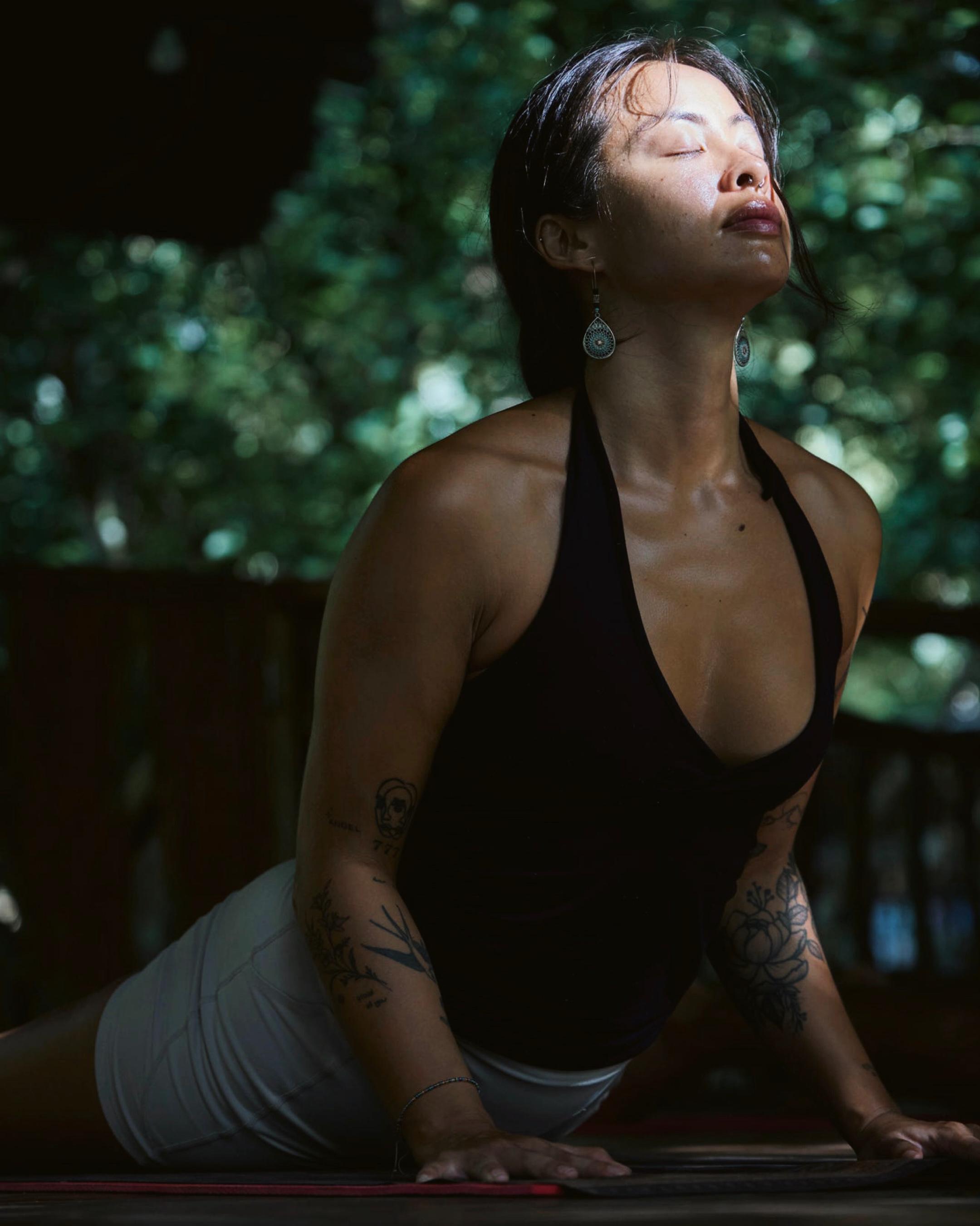 A guest in an upward facing dog on the open air shala deck