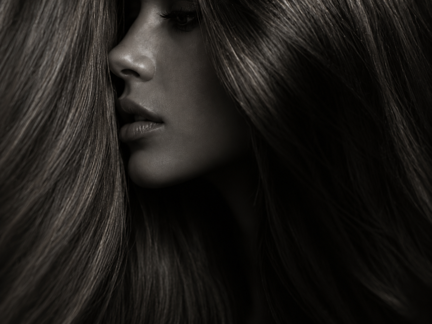 Monochrome editorial portrait highlighting glossy dark hair