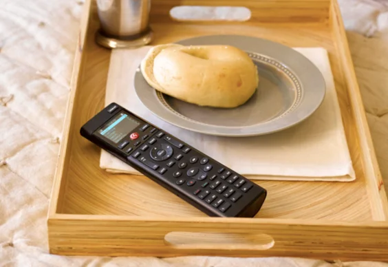 Control4 handheld remote on a breakfast tray, one remote for the whole room