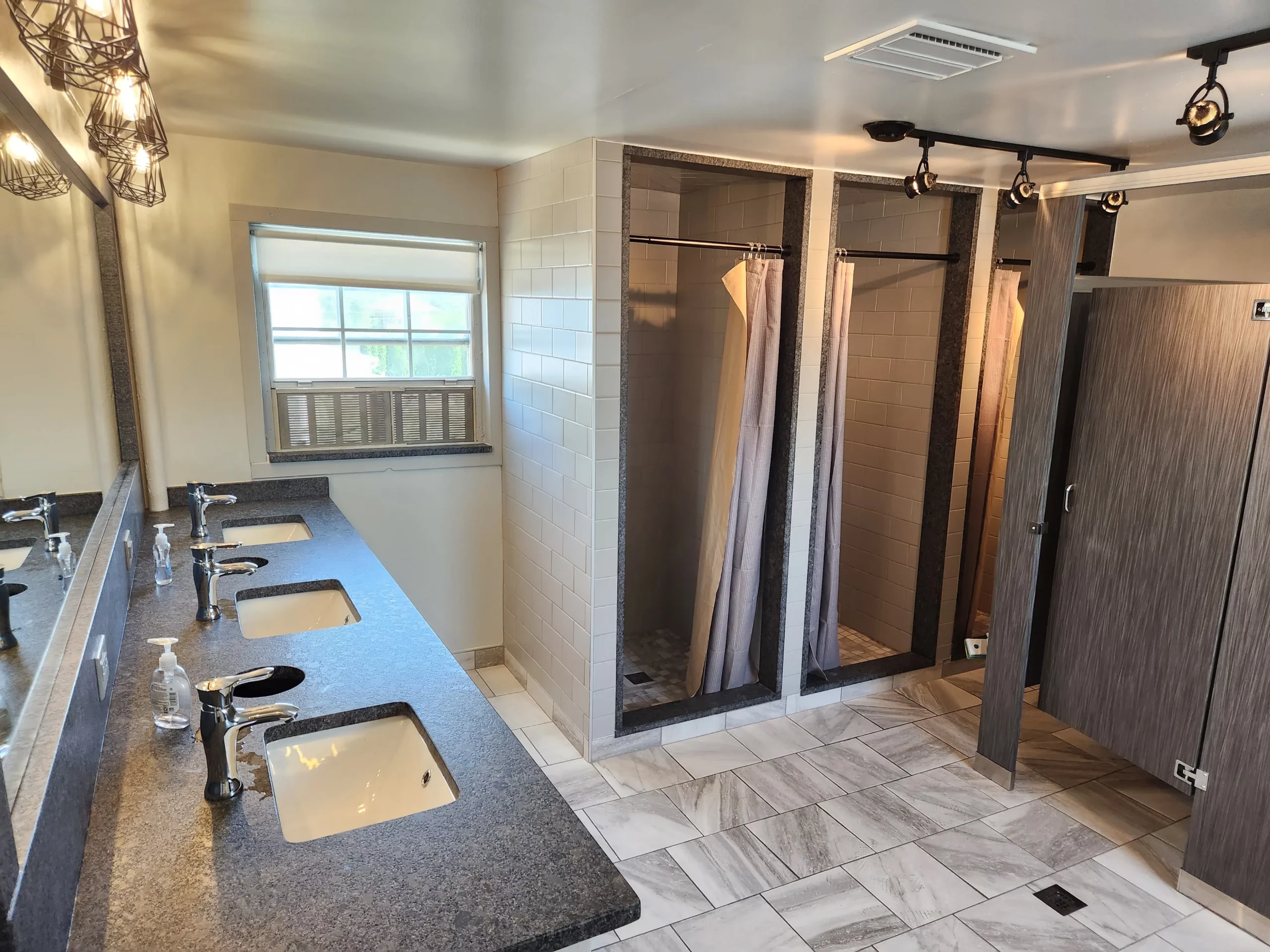 Shared bathroom facility with sinks and private stalls