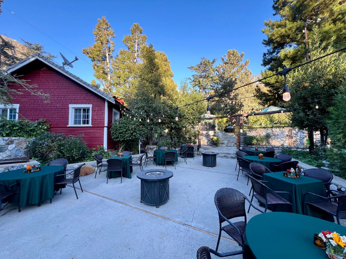 Patio tables and fire pits beside the red cabins