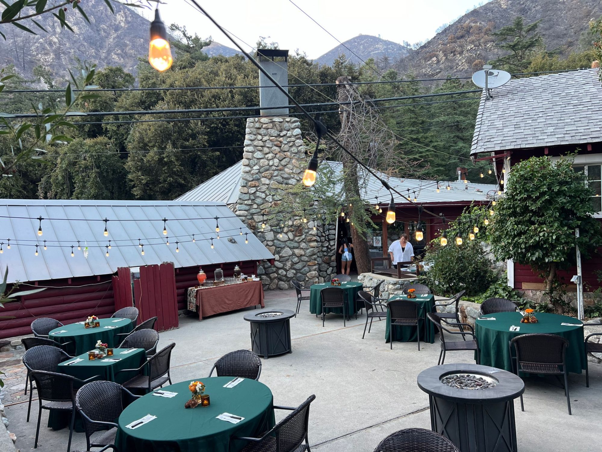 The patio, stone chimney and the mountain at golden hour