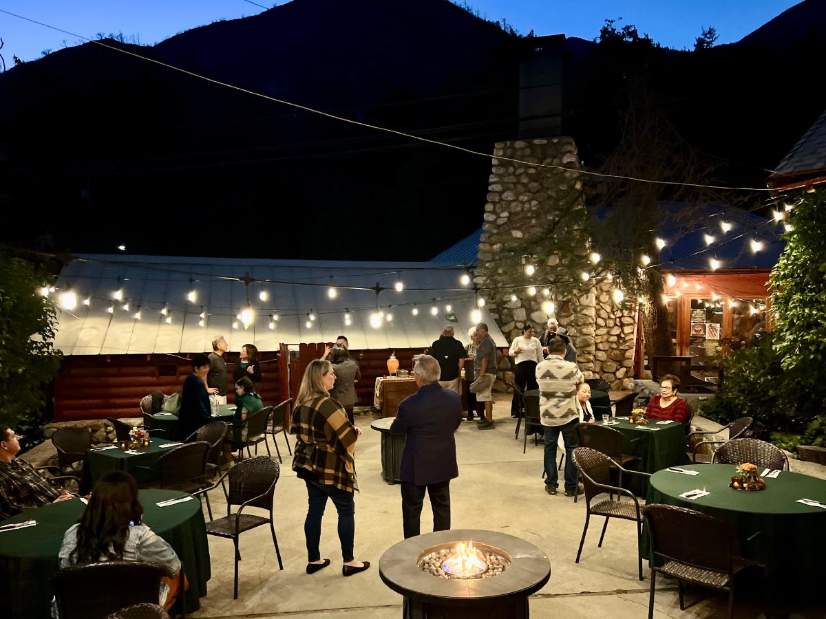 The patio at night under string lights with guests