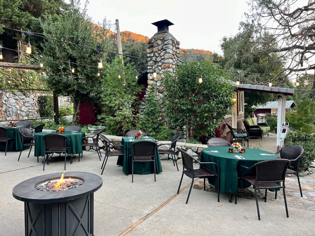 The patio with the stone chimney and the mountain behind