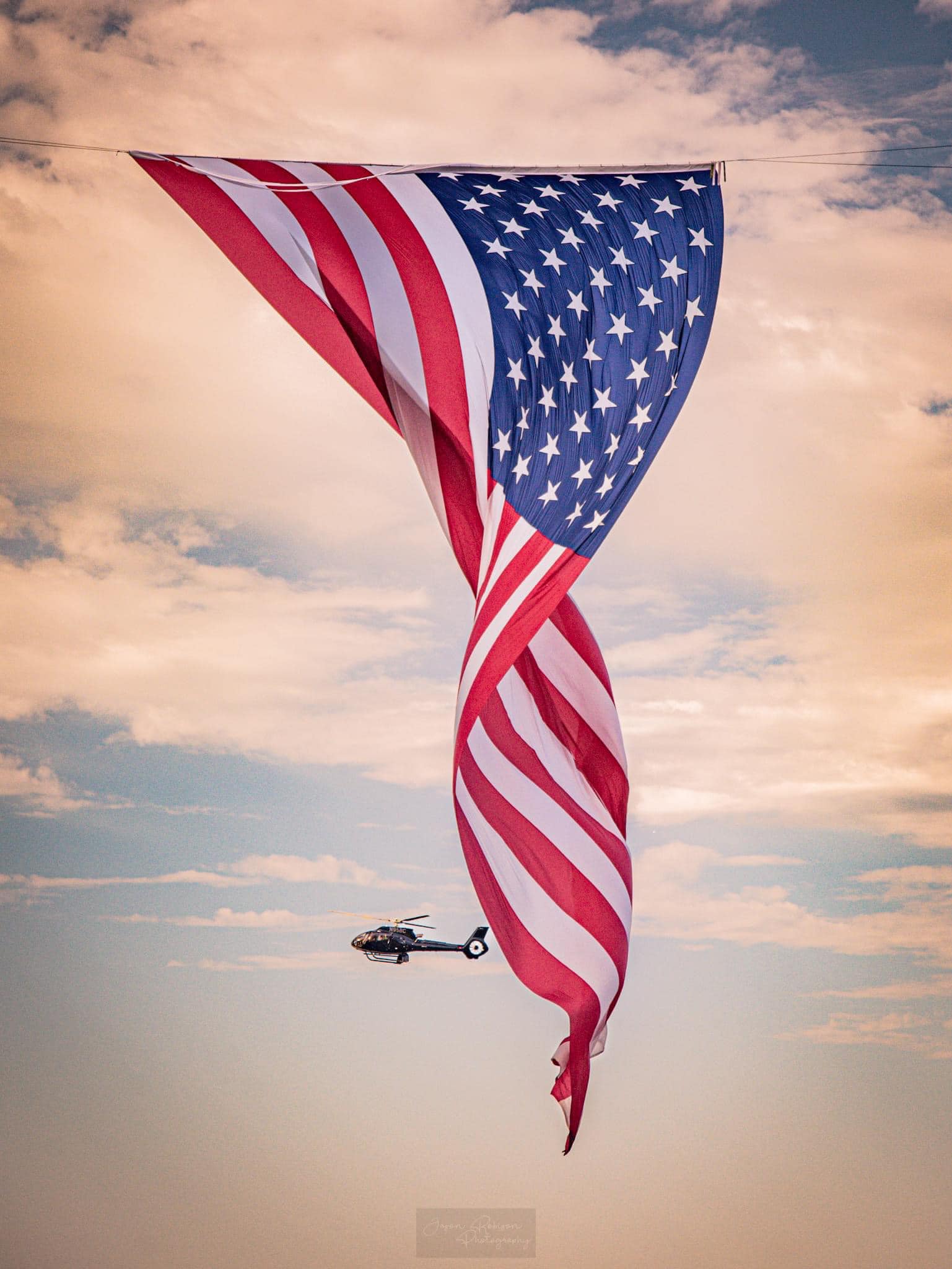 Veterans and families reflecting beneath the giant flag at Snow Canyon