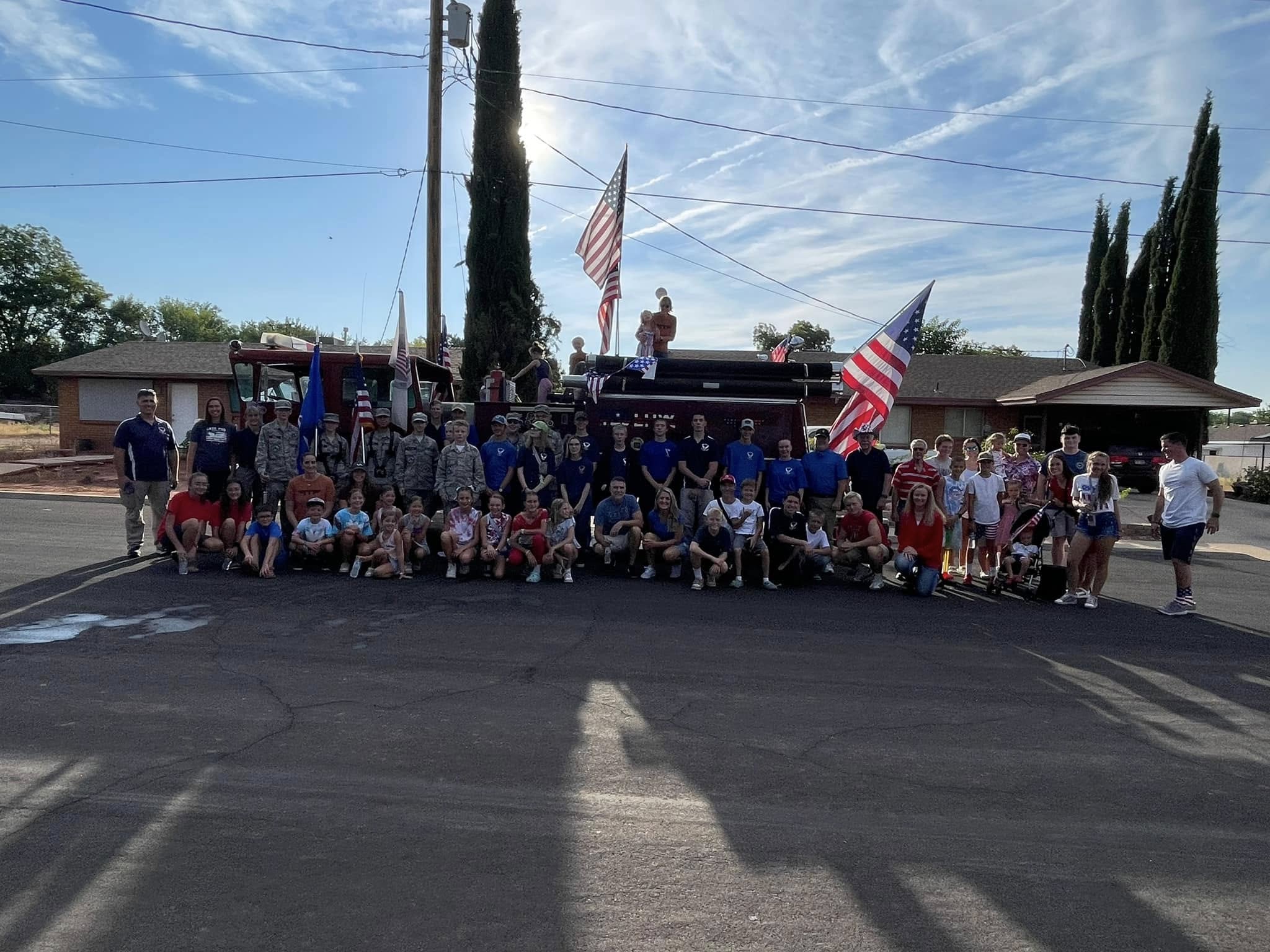 Veterans and families standing in reflection beneath the flag