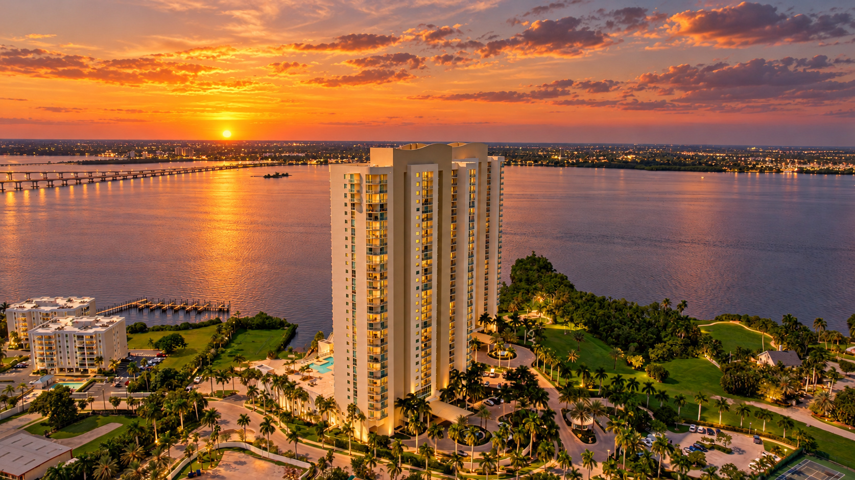 Twilight aerial view of Oasis Grand on the Caloosahatchee River at sunset in downtown Fort Myers FL, home of 3000 Oasis Grand Blvd #1401