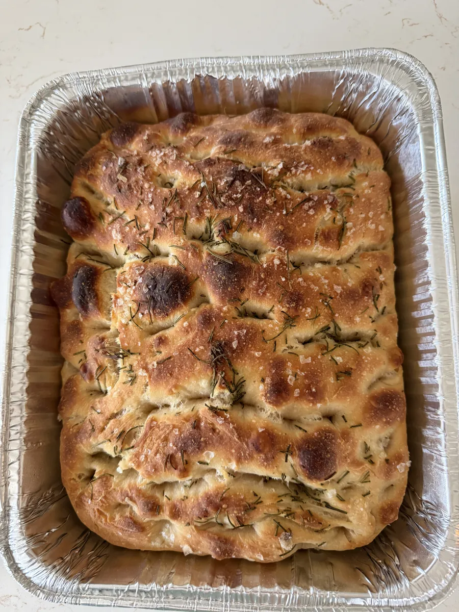 Golden sourdough focaccia in a baking pan