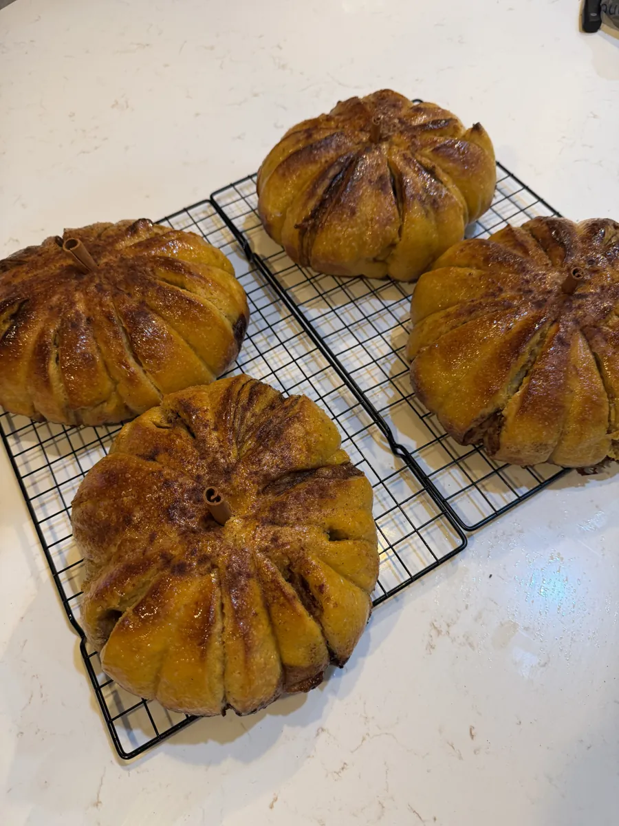 Pumpkin-shaped sourdough loaves cooling on a rack
