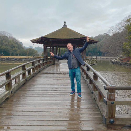 Kenny in Japan, arms raised in joy