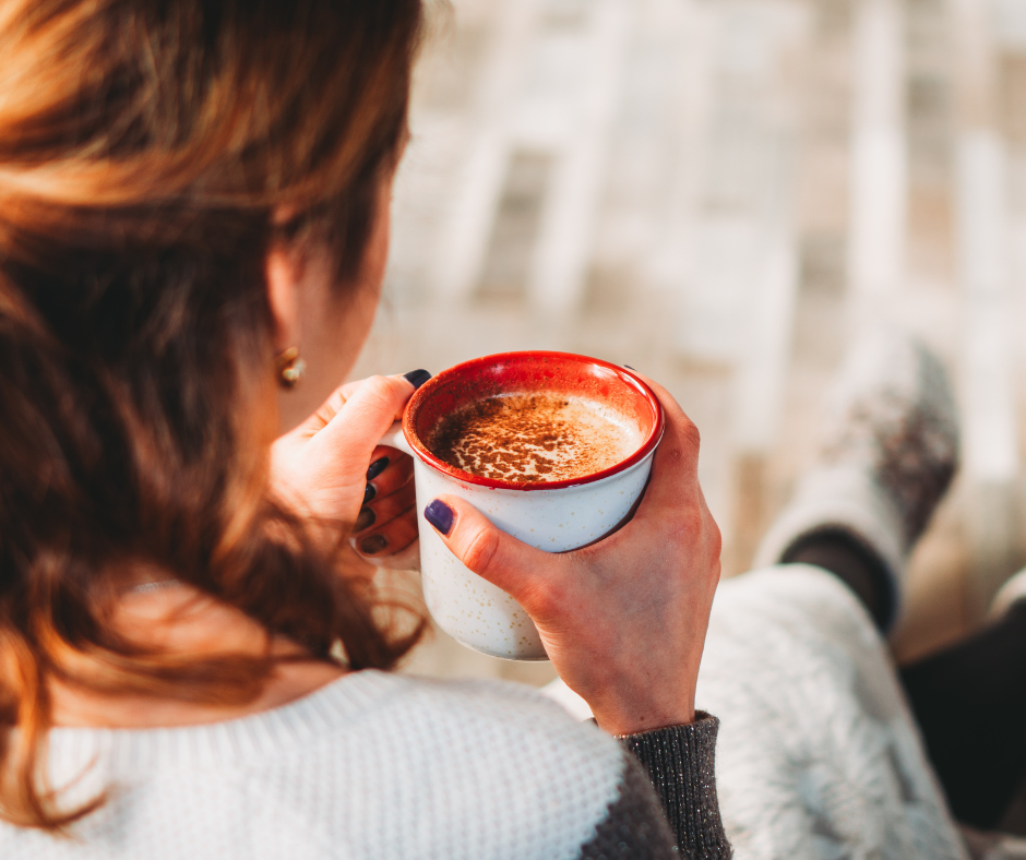 A woman sitting quietly, holding a cup of coffee