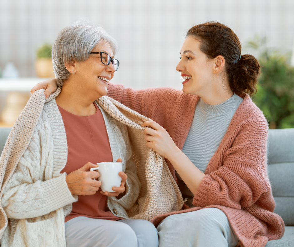 Adult daughter and mother sitting together on a couch during a difficult conversation