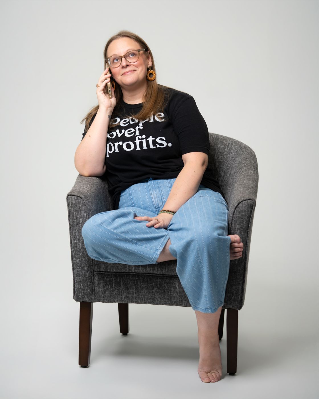 Tara in an armchair, talking on the phone