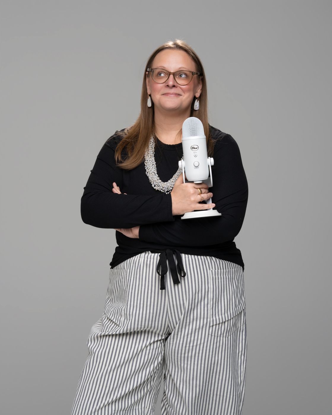 Tara standing with a white microphone held against her chest