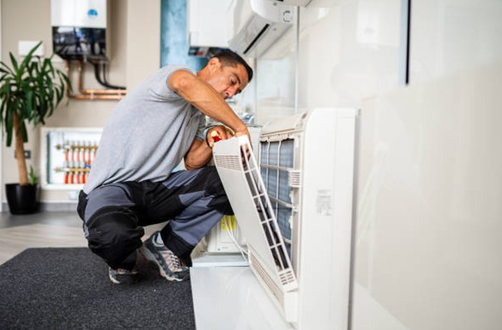 HVAC technician inspecting indoor air handler filter during an annual HVAC maintenance plan visit HVAC technician inspecting indoor air handler filter during an annual HVAC maintenance plan visit