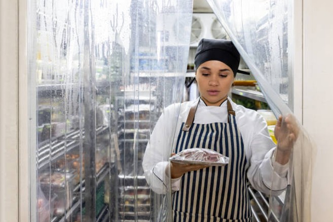 Restaurant staff moving inventory from a walk-in cooler during a commercial refrigeration repair emergency Restaurant staff moving inventory from a walk-in cooler during a commercial refrigeration repair emergency