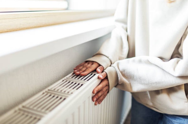 Homeowner checking heating while considering HVAC financing options for a system replacement Homeowner checking heating while considering HVAC financing options for a system replacement
