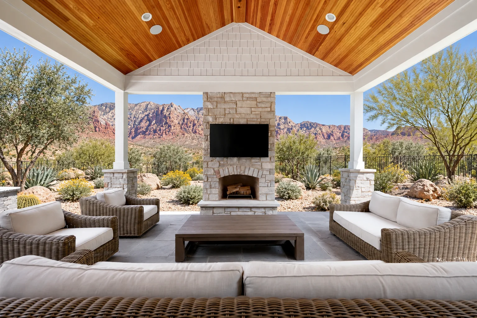 Nevada design concept: warm wood ceiling, white shake siding, and stone fireplace overlooking a desert garden