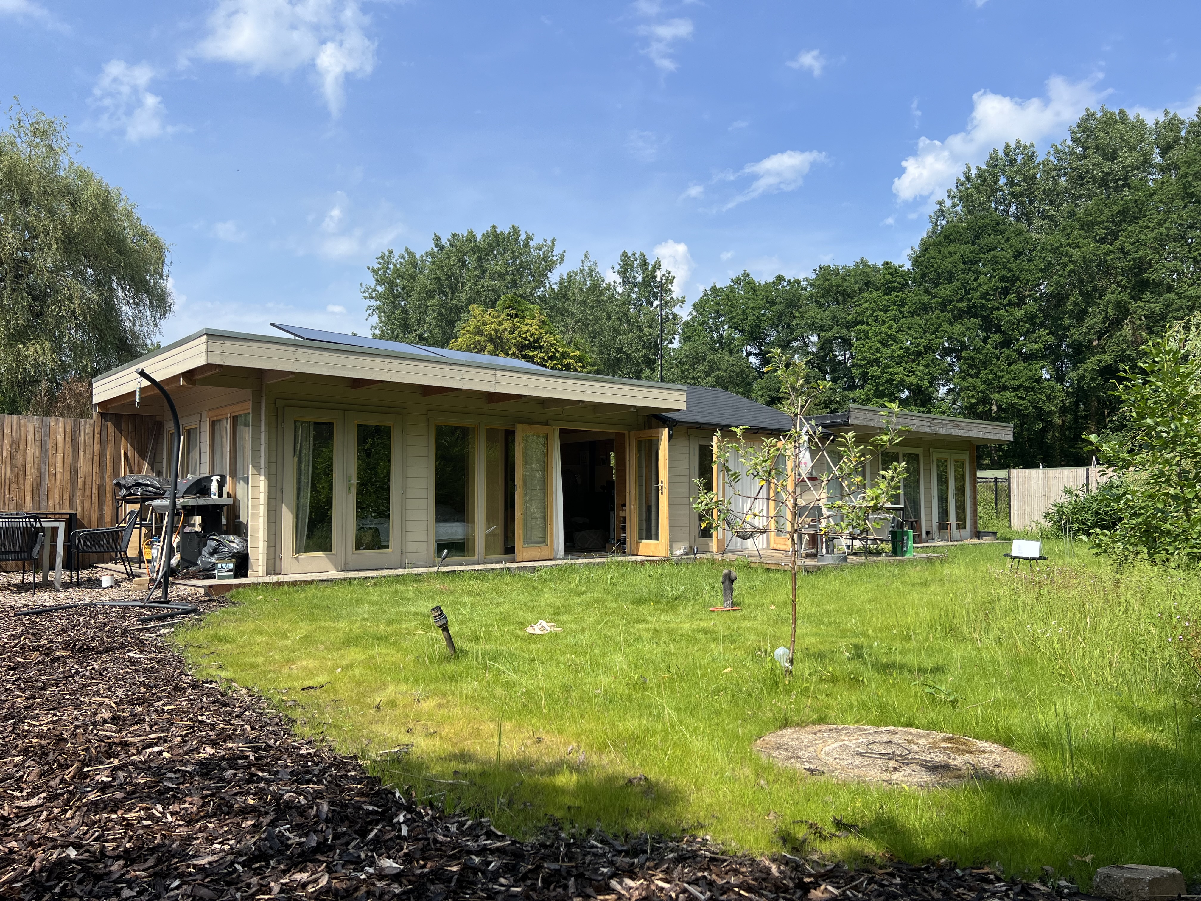 Off-grid tiny home gebouwd door Droomstek in Vlaanderen België, houten gevel met groene tuin