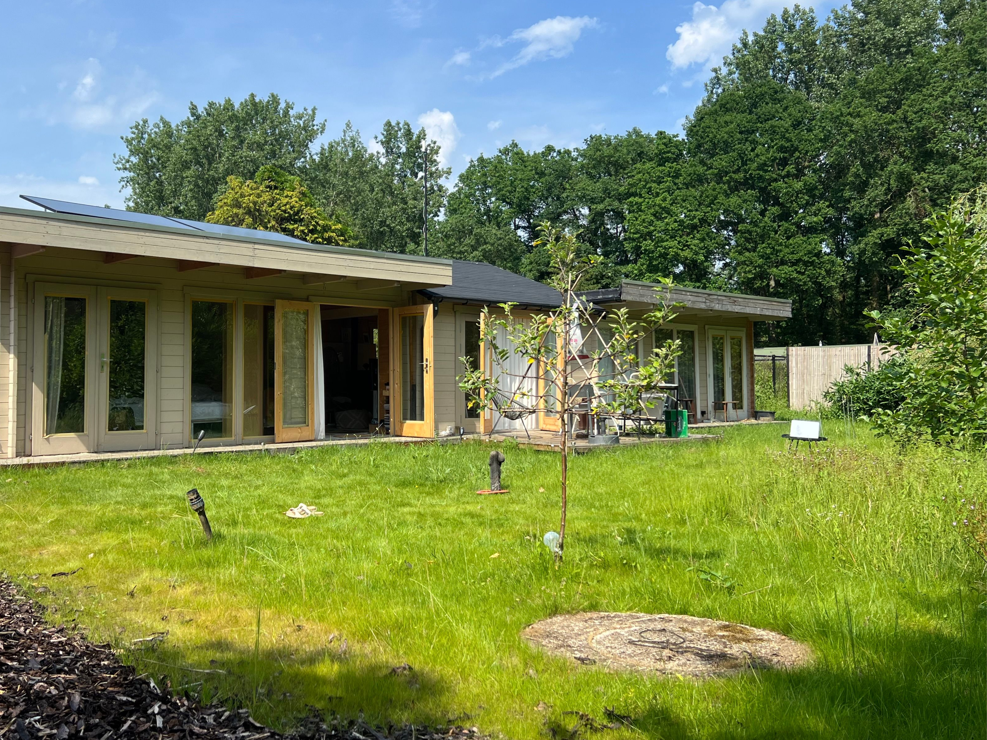 Off-grid tiny home gebouwd door Droomstek in Vlaanderen België, houten gevel met groene tuin