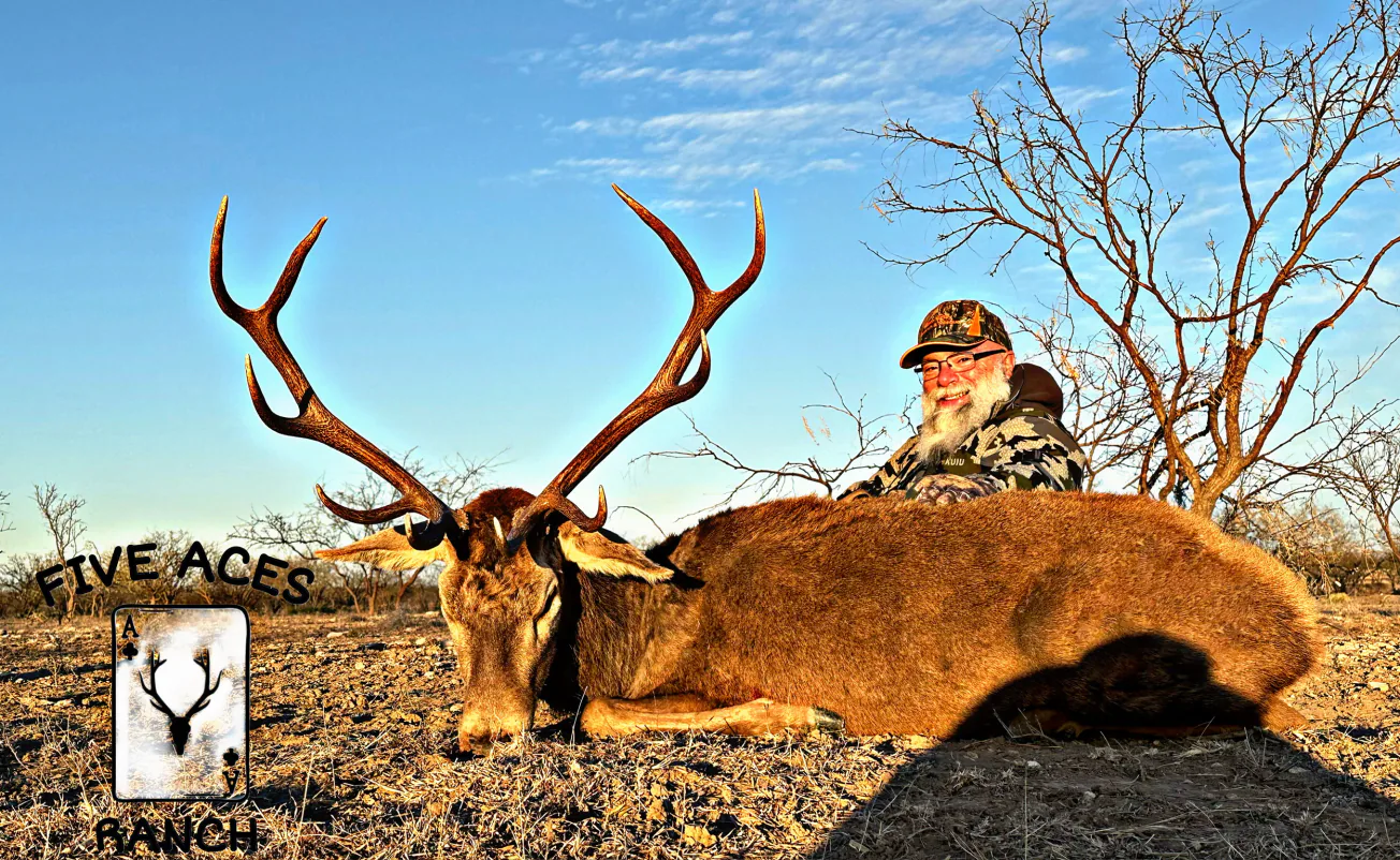 Hunter with trophy axis deer harvested at Five Aces Ranch in Millersview, TX.