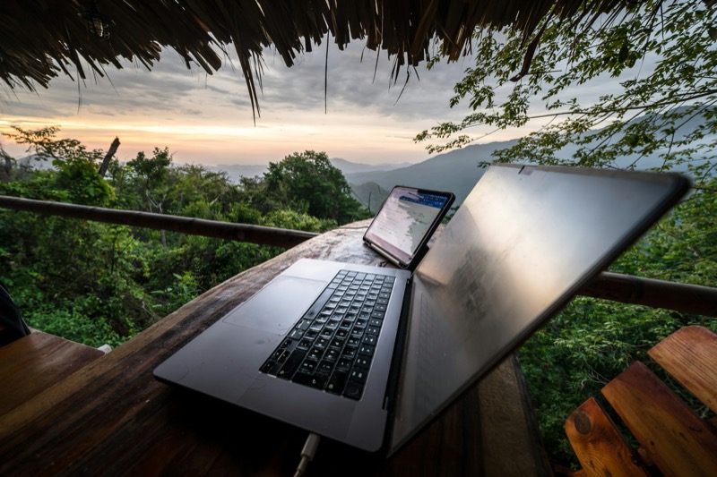 Laptop op een balkon met uitzicht over jungle