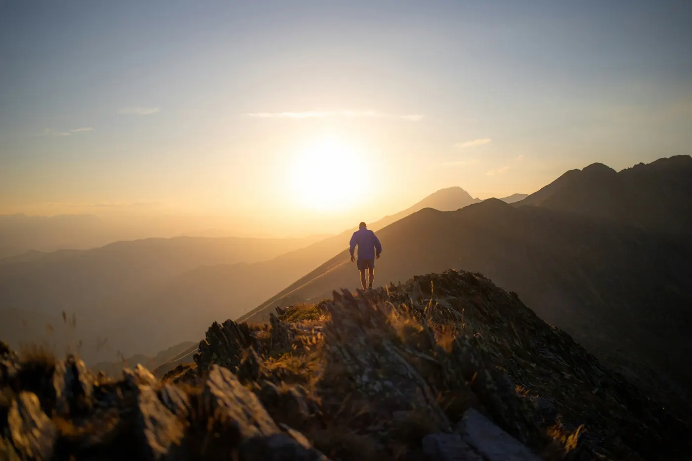 Wandelaar op een bergkam bij zonsopkomst