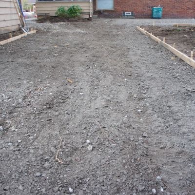 Ground prepared with dirt and wooden forms for concrete work.