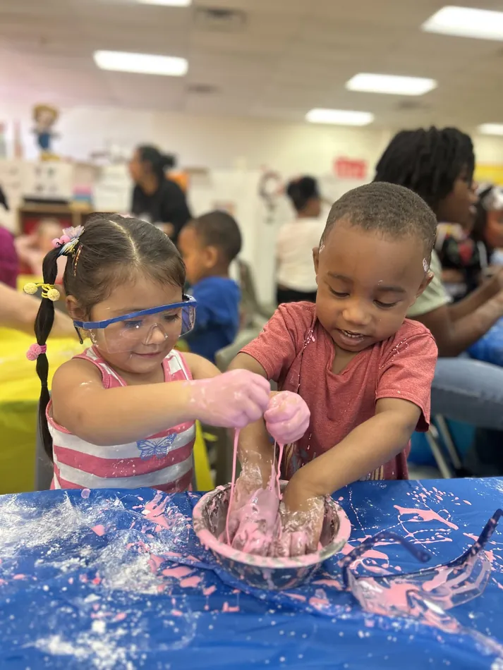 A child wearing safety goggles during a hands-on science activity at François Academy