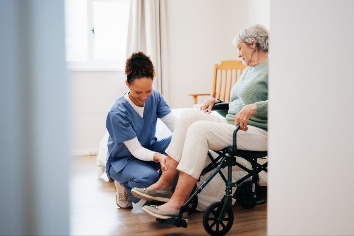 A caregiver assisting a senior seated in a power wheelchair to ensure comfort and safety. A caregiver assisting a senior seated in a power wheelchair to ensure comfort and safety.