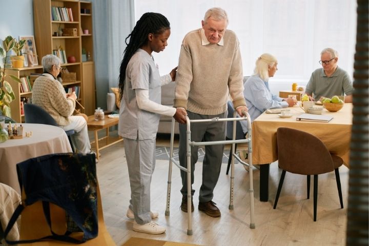 A caregiver assisting a senior with a walker provided by a trusted mobility equipment supplier near me.