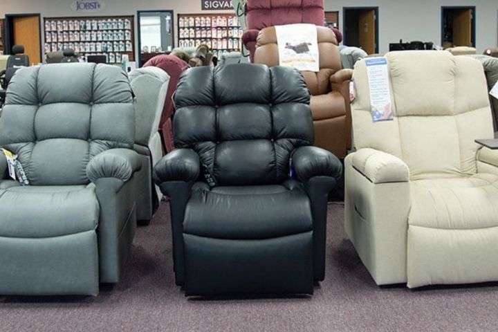 Three different color models of Lift chairs for elderly displayed in a showroom.