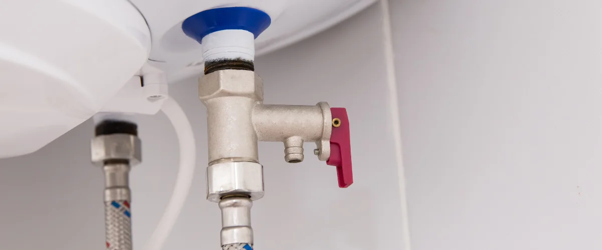 Close-up of water heater pressure relief valve and plumbing connections. Close-up of water heater pressure relief valve and plumbing connections.