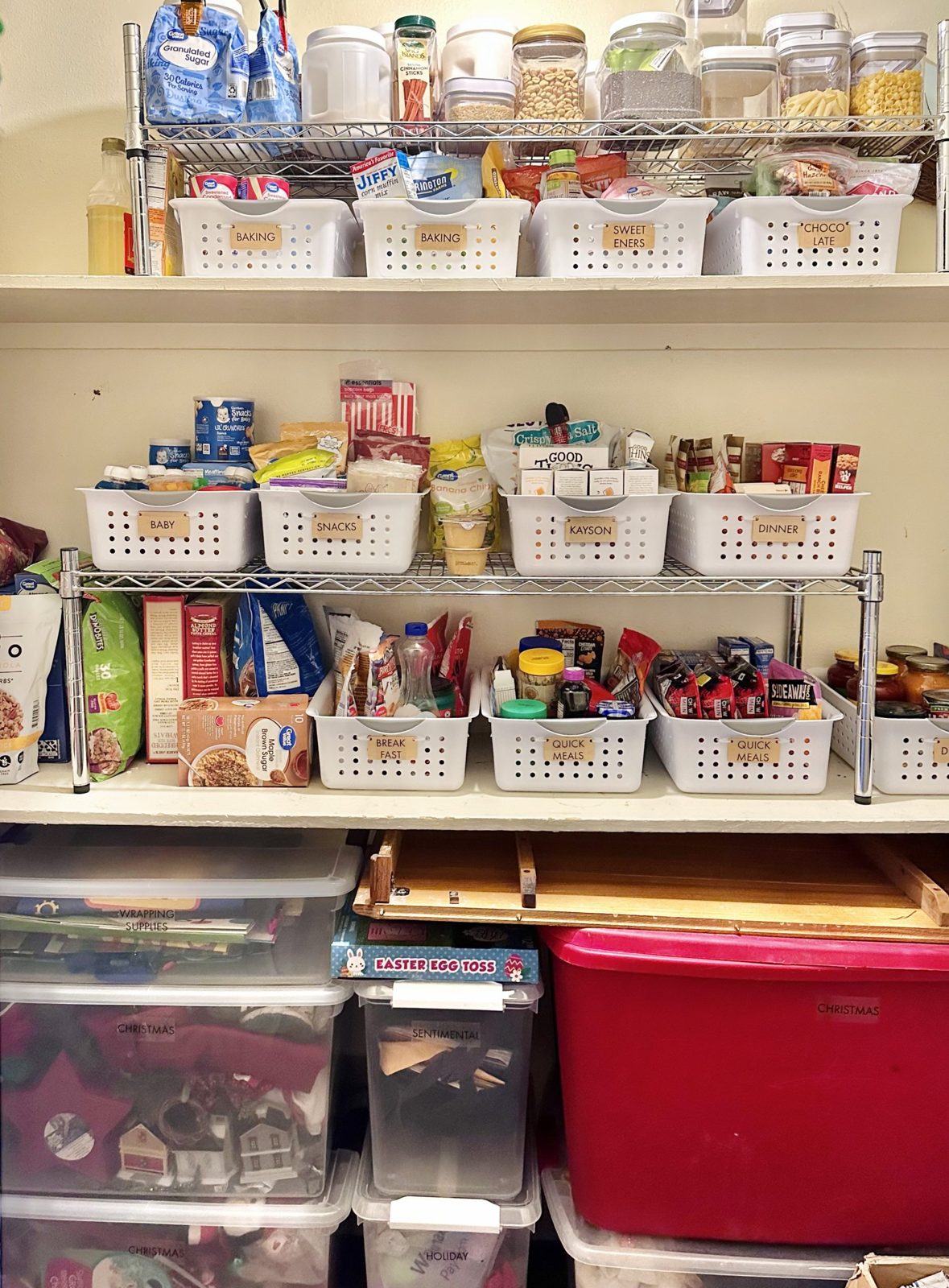 Finished pantry shelves with labeled baskets and seasonal bins below