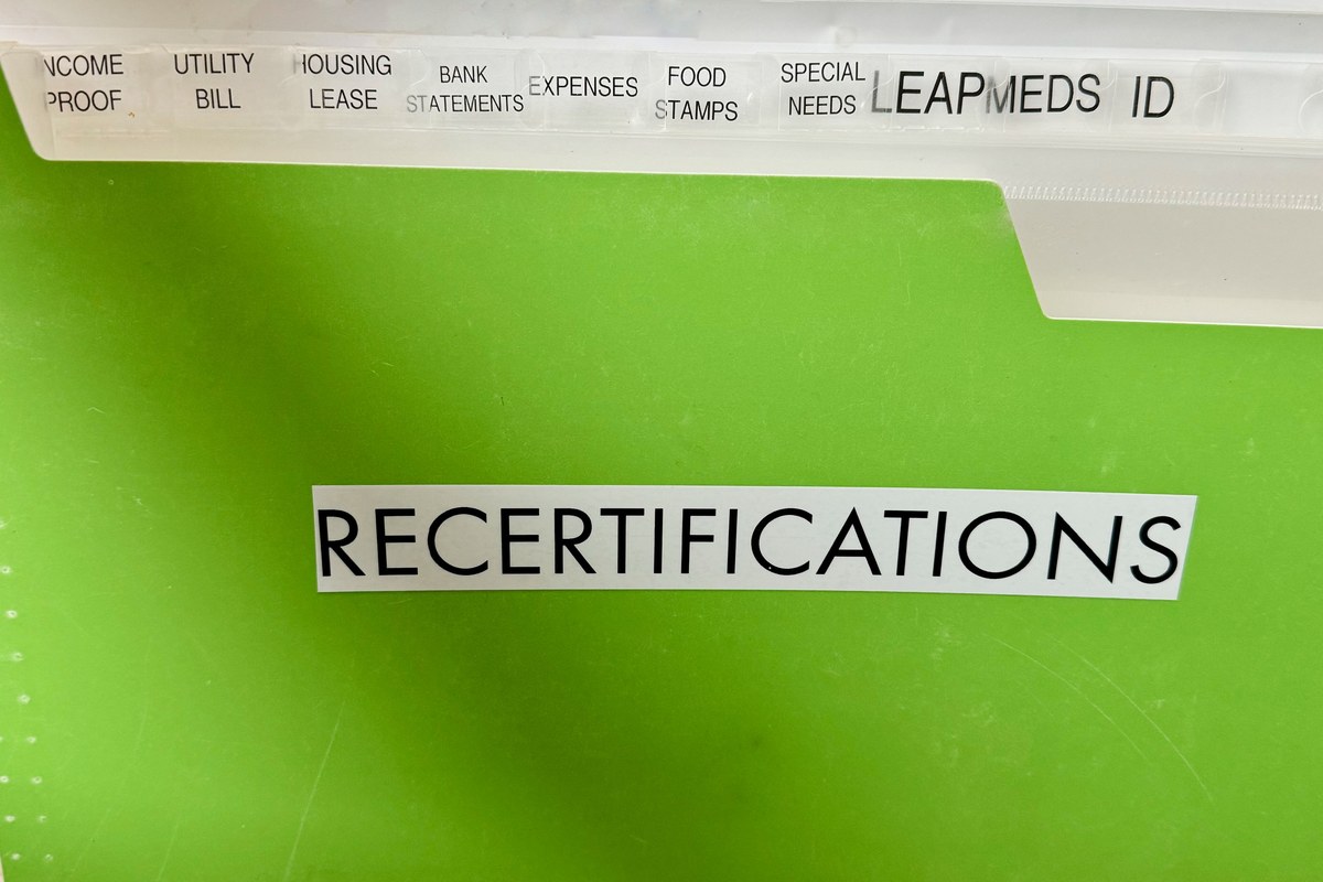A green accordion file labeled Recertifications with labeled tabs for each document type