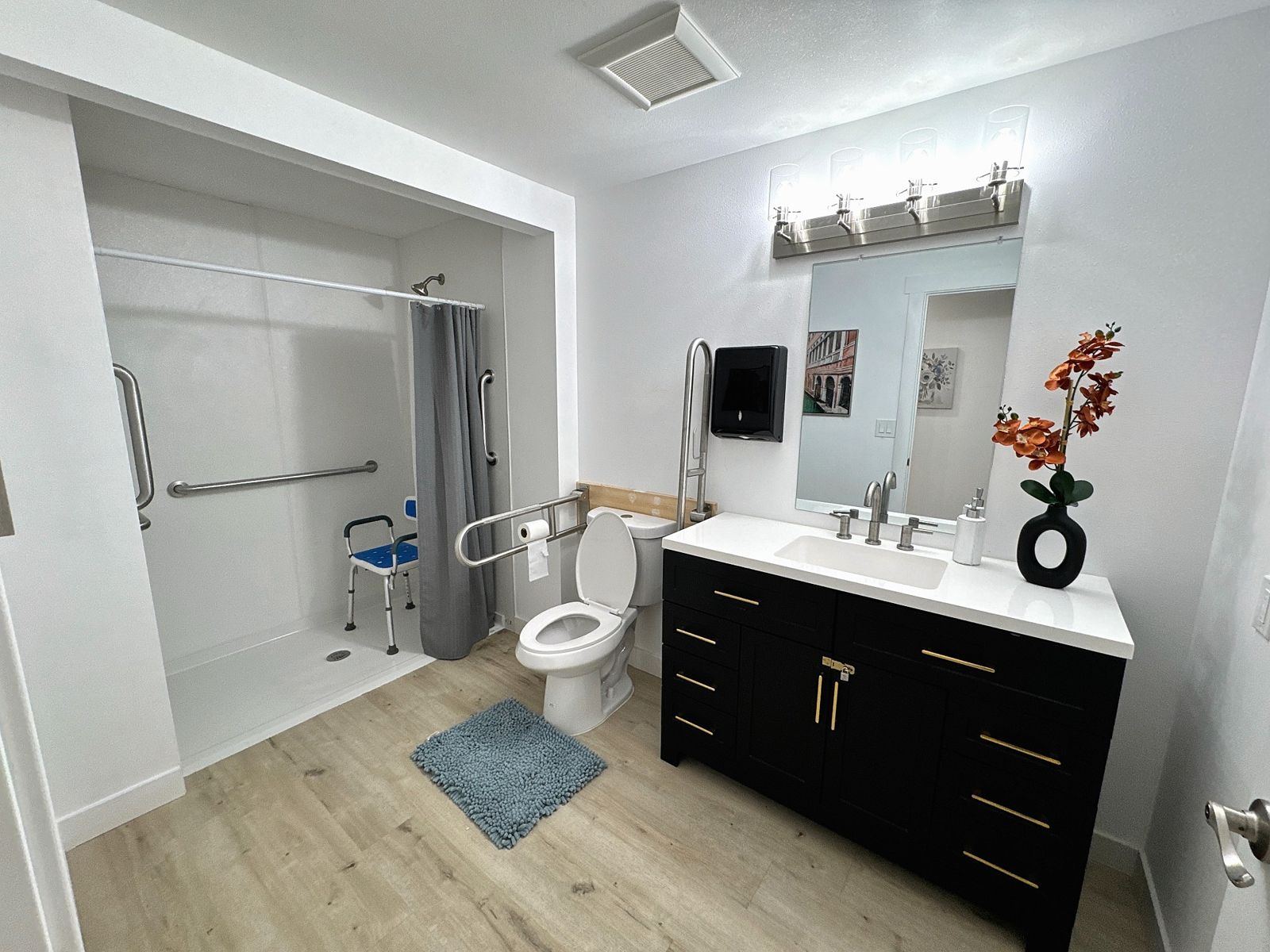Second accessible bathroom with grab bars and shower seat