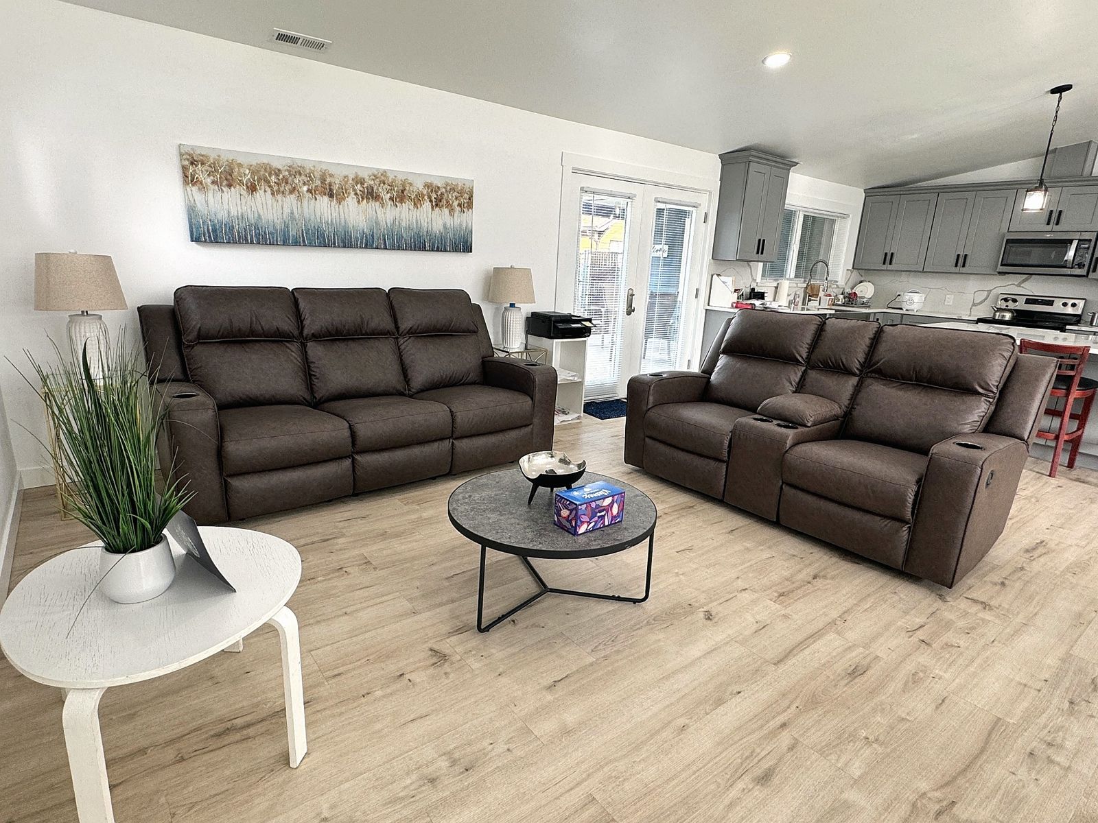 Bright living room with recliners, open to the kitchen