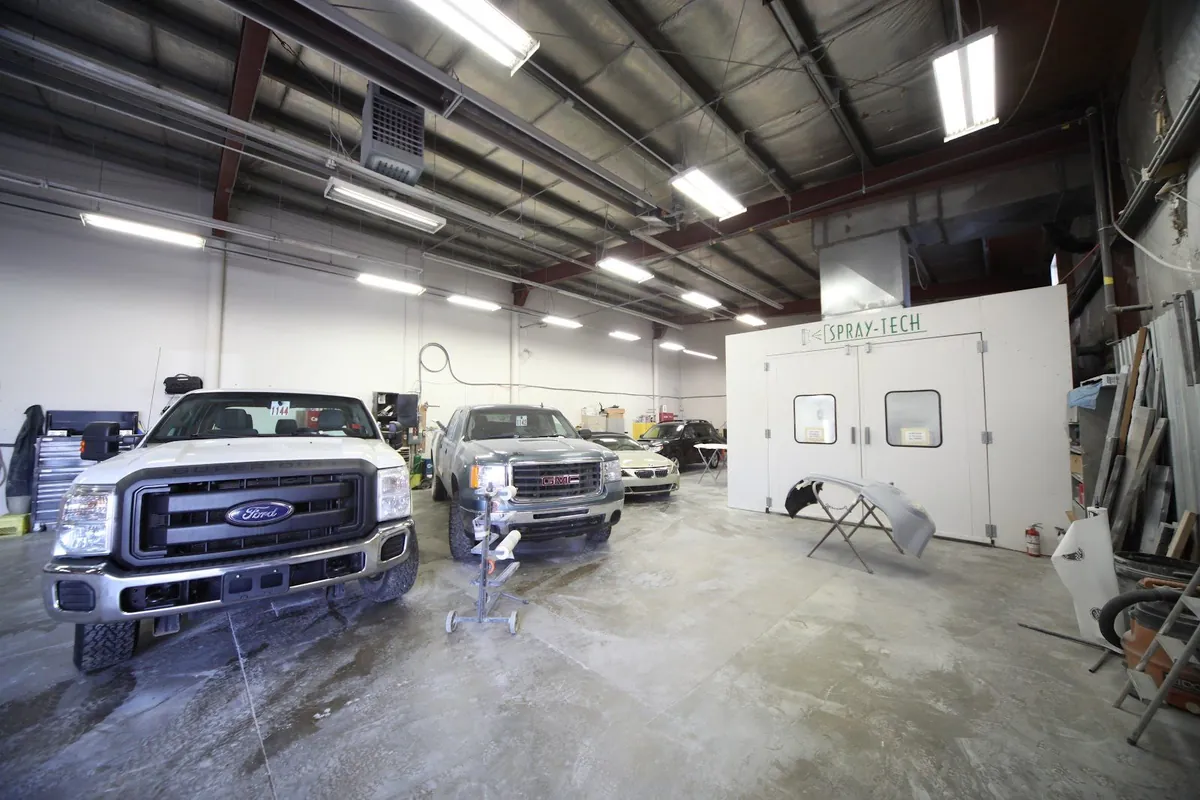 Inside the Master Auto Body shop with the spray booth and vehicles in the work bays