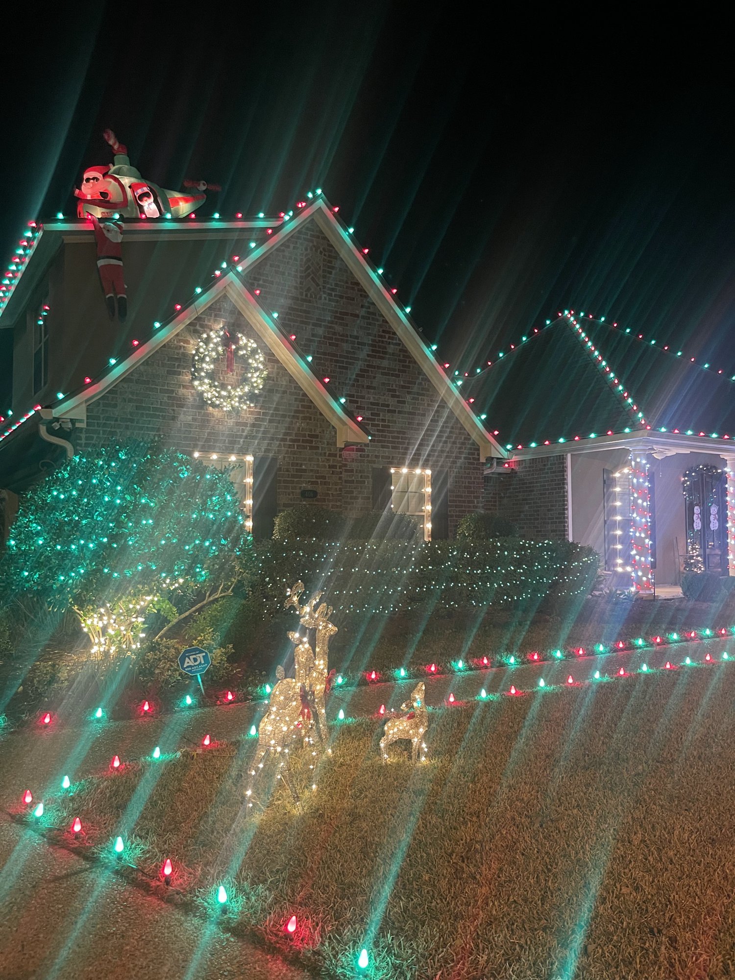 Brick home in red and green Christmas lights