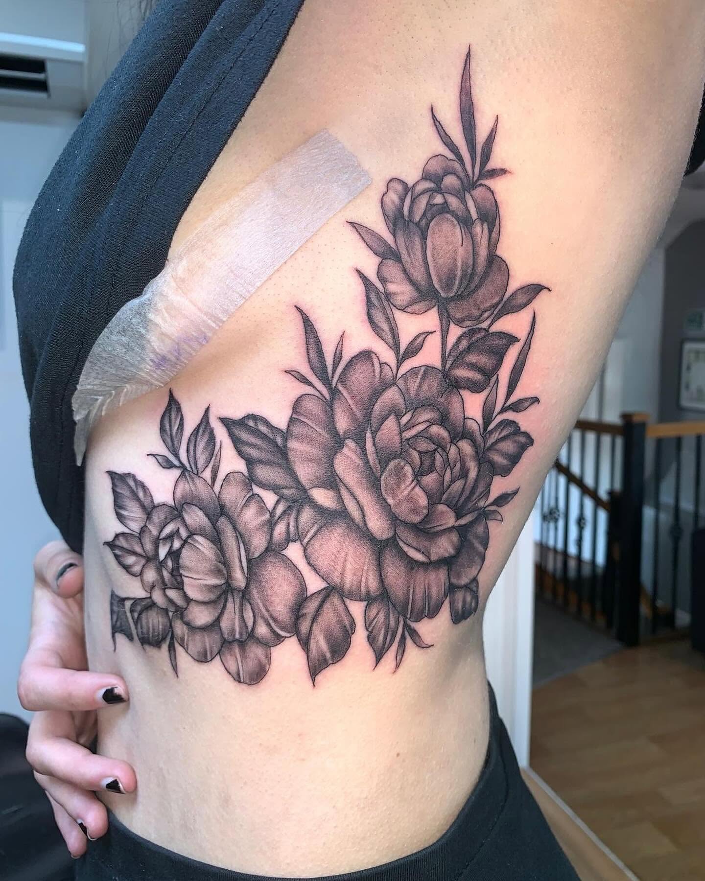 Fine line and floral tattoo work by the Tattoo Phil's team
