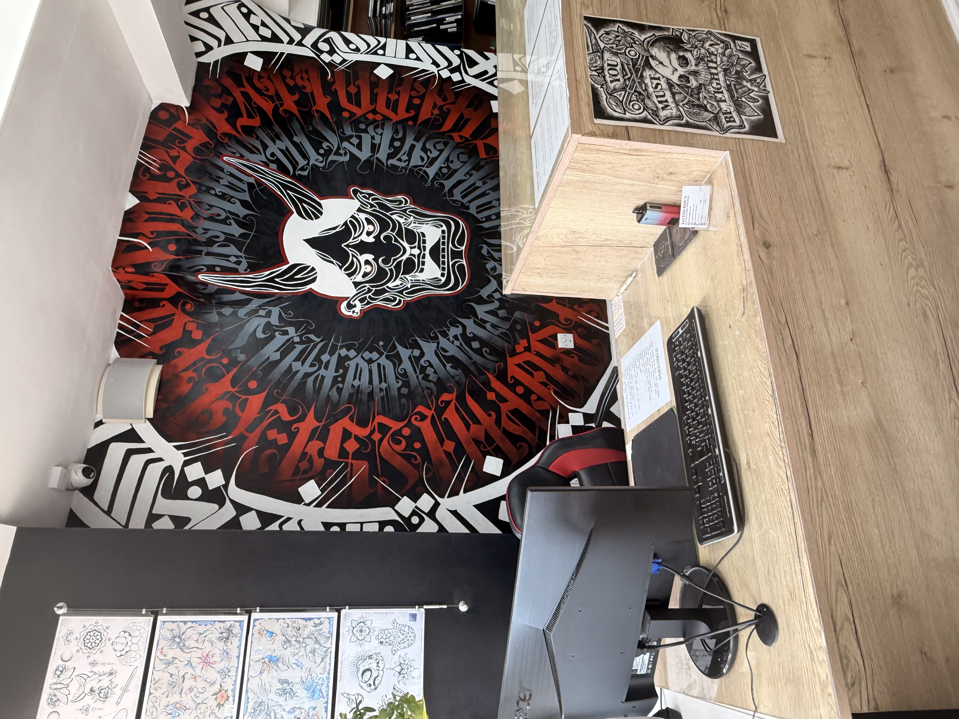 Reception counter beneath Tattoo Phil's feature mural
